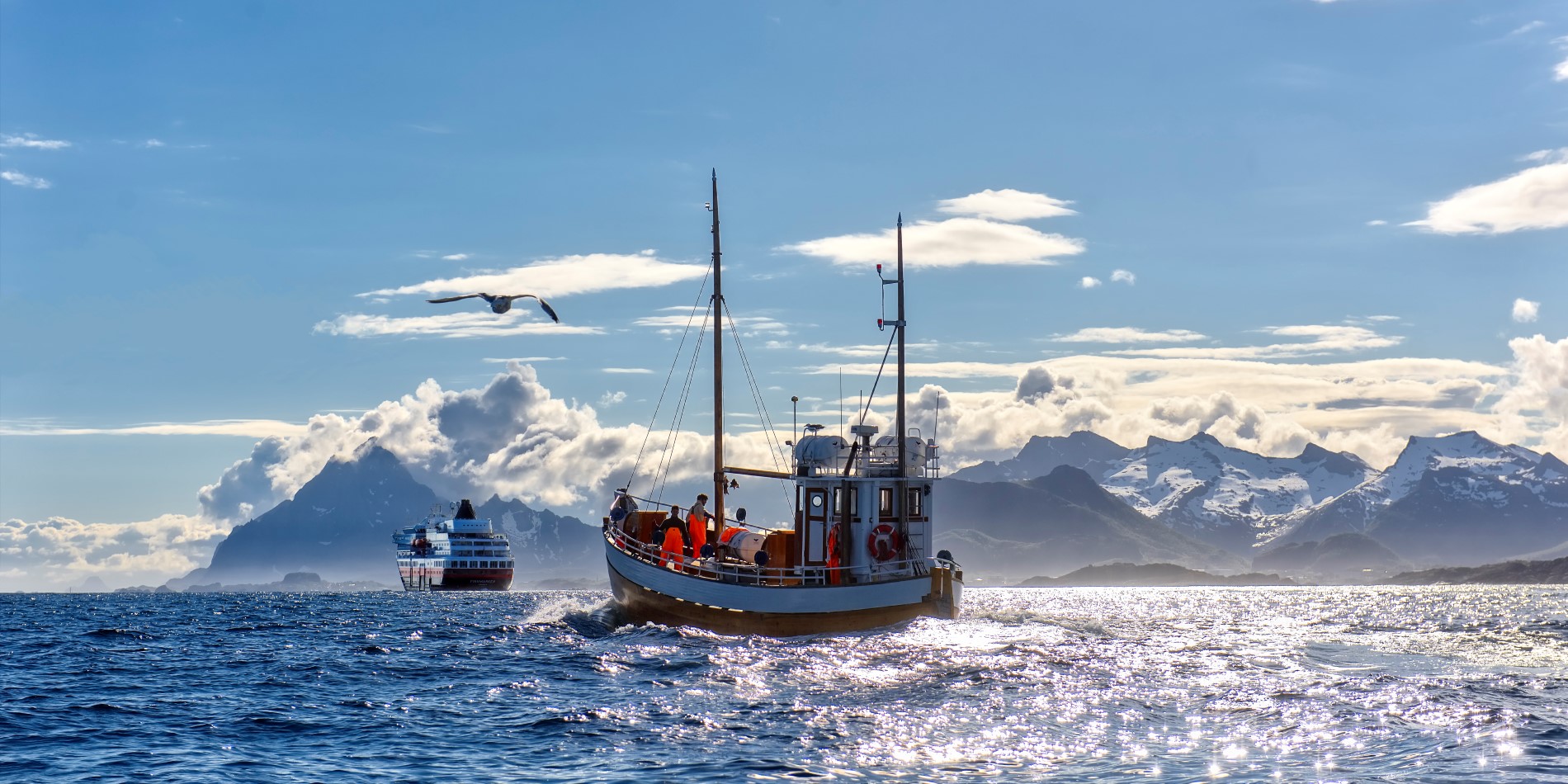 Et av Hurtigrutens skip seiler inn i horisonten med en lokal fiskerbåt bak seg 