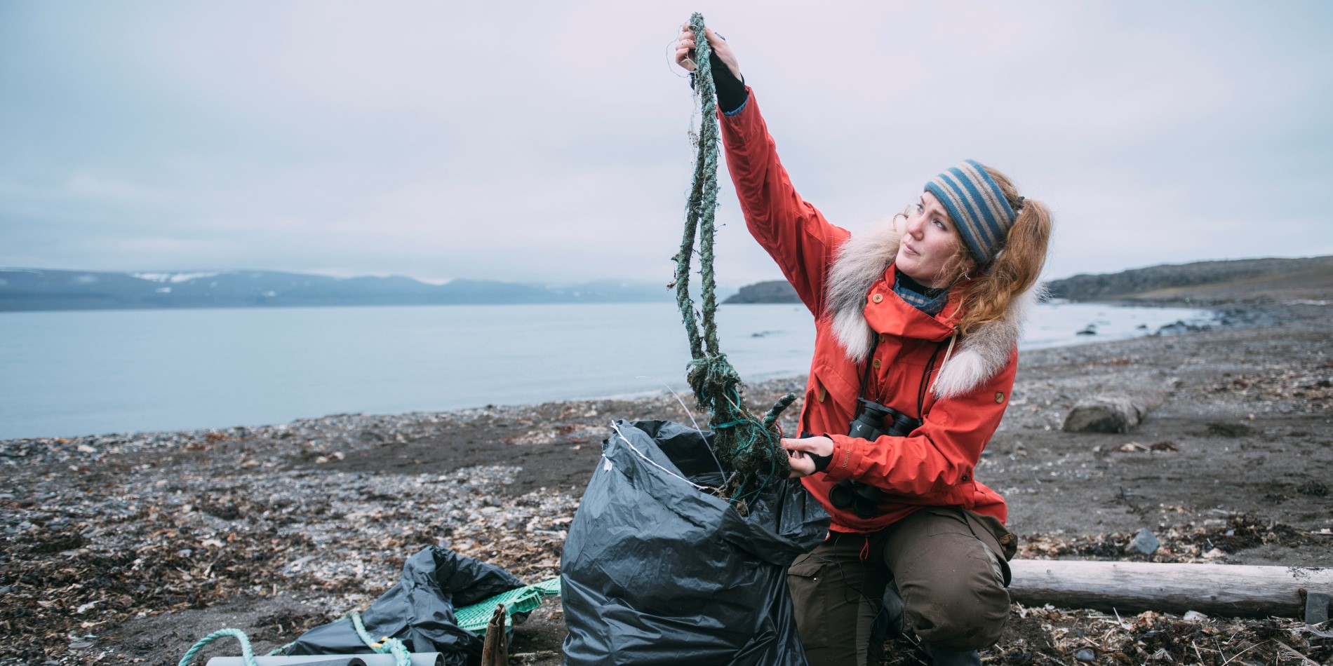 Biolog og ekspedisjonsleder Helga Bårdsdatter Kristiansen er på en strand full av søppel, hvor hun rydder opp