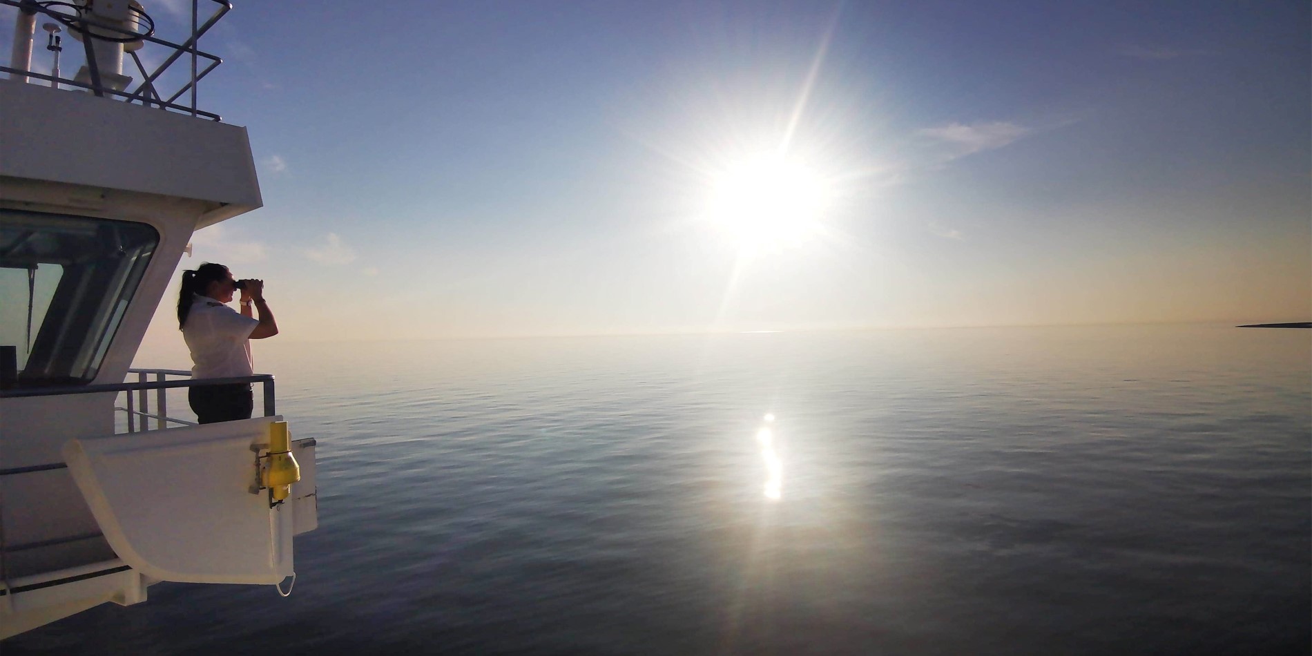Kaptein Maryann Bendiksen ser på en vakker, blå solnedgang