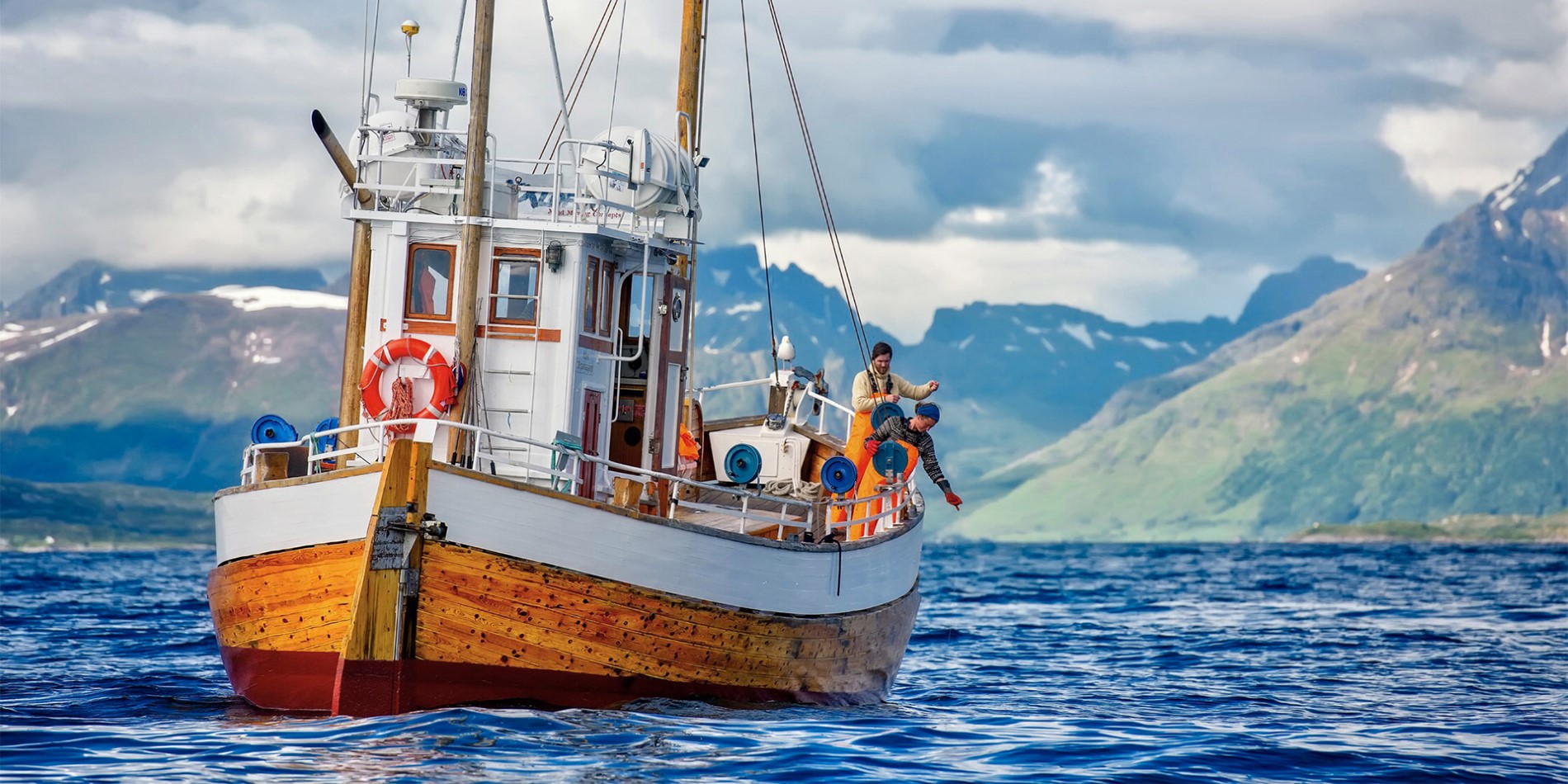 En fiskebåt med to fiskere i Nord-Norge