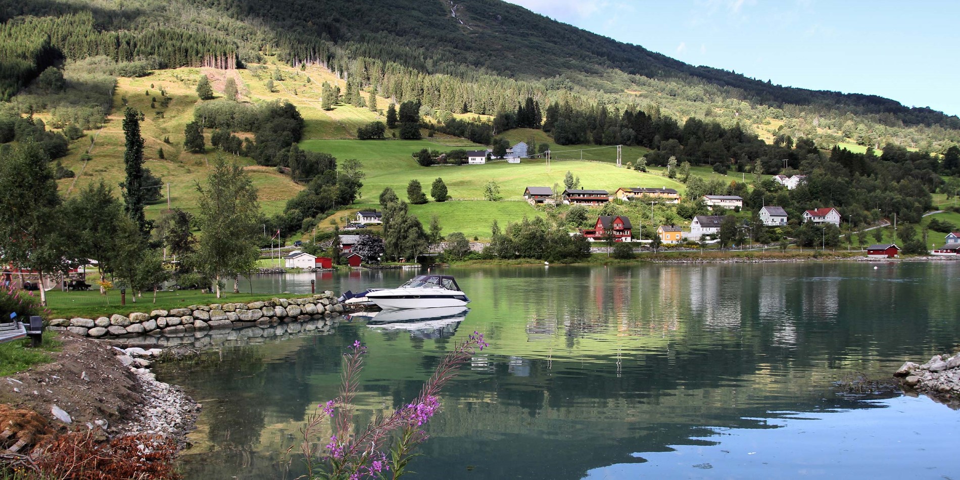 Nordfjord sin kyst med båter og hus.
