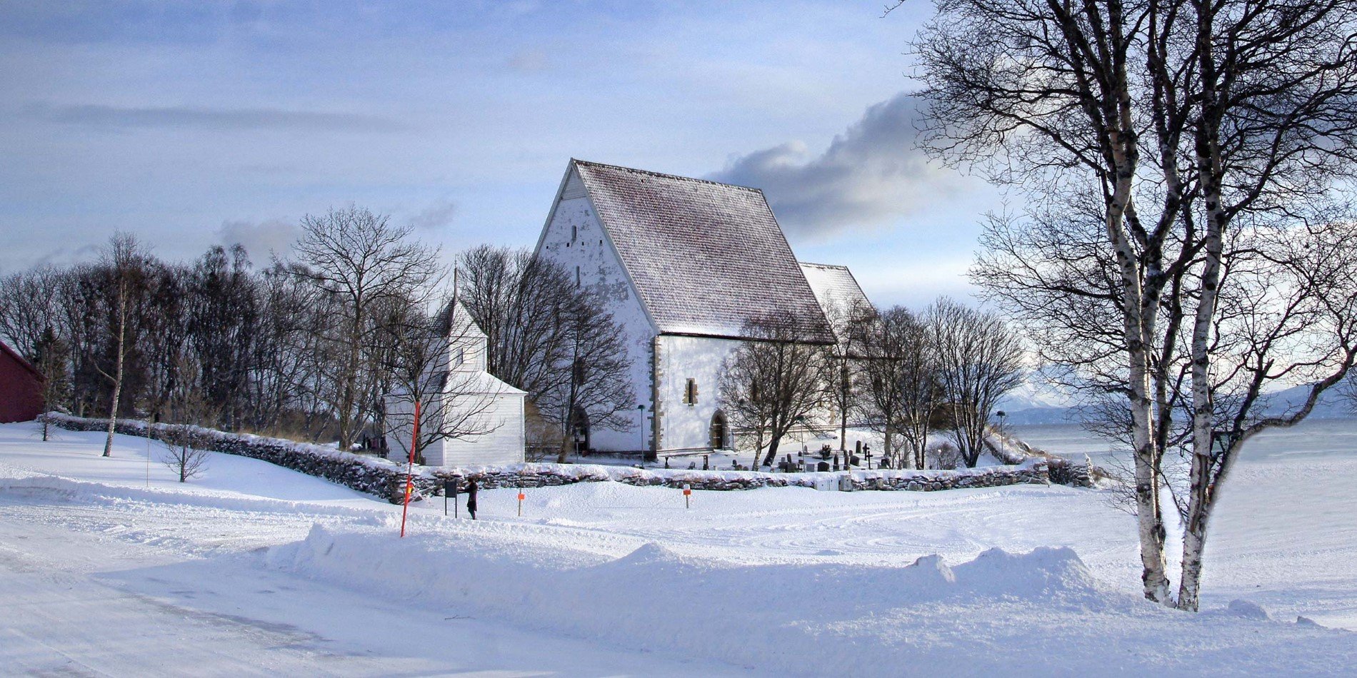 Trondenes kirke om vinteren med turist.