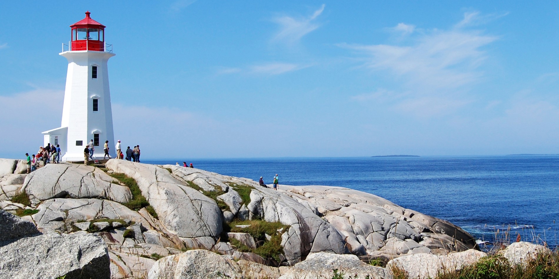 En statue av en person som sitter på en stein nær havet